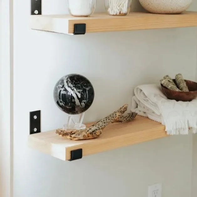 Globe Mova Constellations posé sur une étagère en bois dans un intérieur