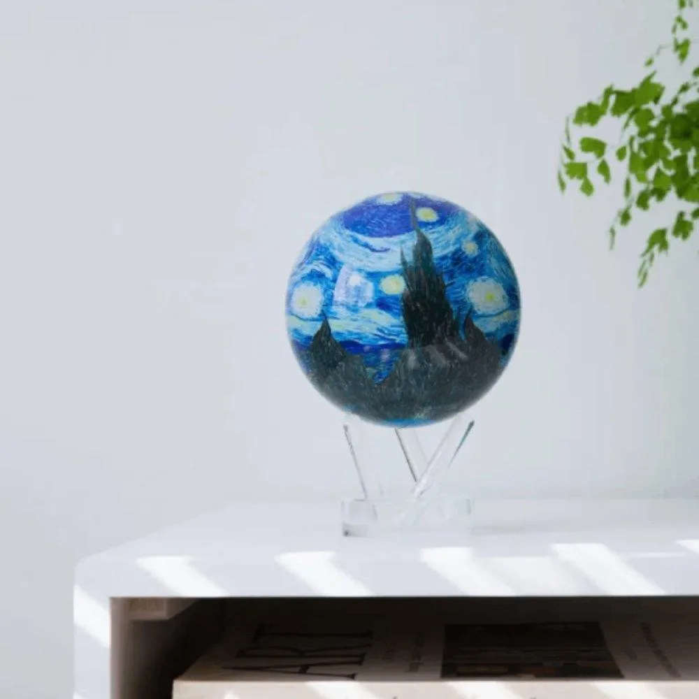 Globe Mova La Nuit étoilée posé sur un bureau près de lunettes