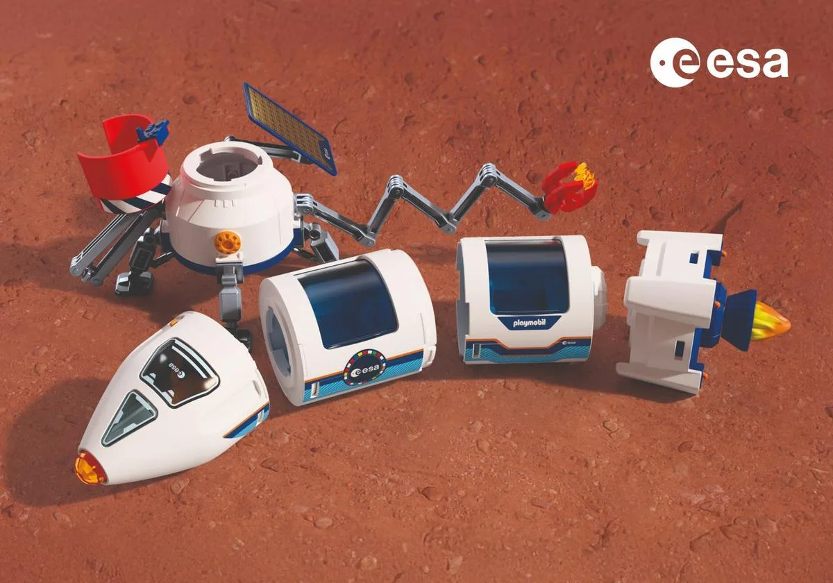 Éléments démontés de la fusée Playmobil de l'ESA sur un décor de sol martien : cabine, deux modules, moteur et plateforme