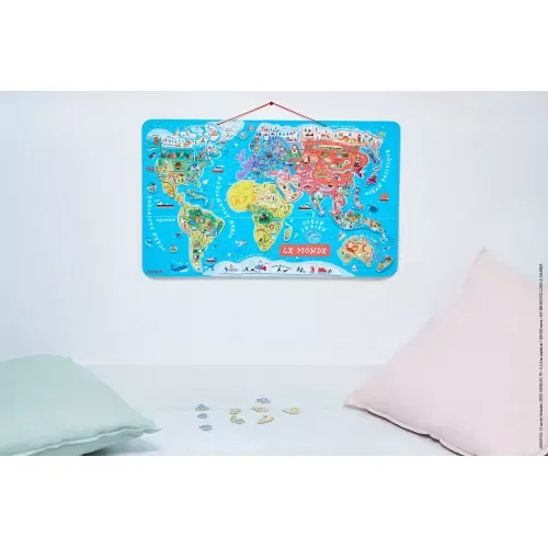 Carte du monde magnétique Janod accrochée au mur d'une chambre d'enfant, avec des aimants posés dessous